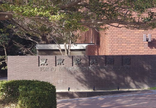 Entrance sign reading Tokyo Metropolitan Art Museum on brick wall in Ueno Park