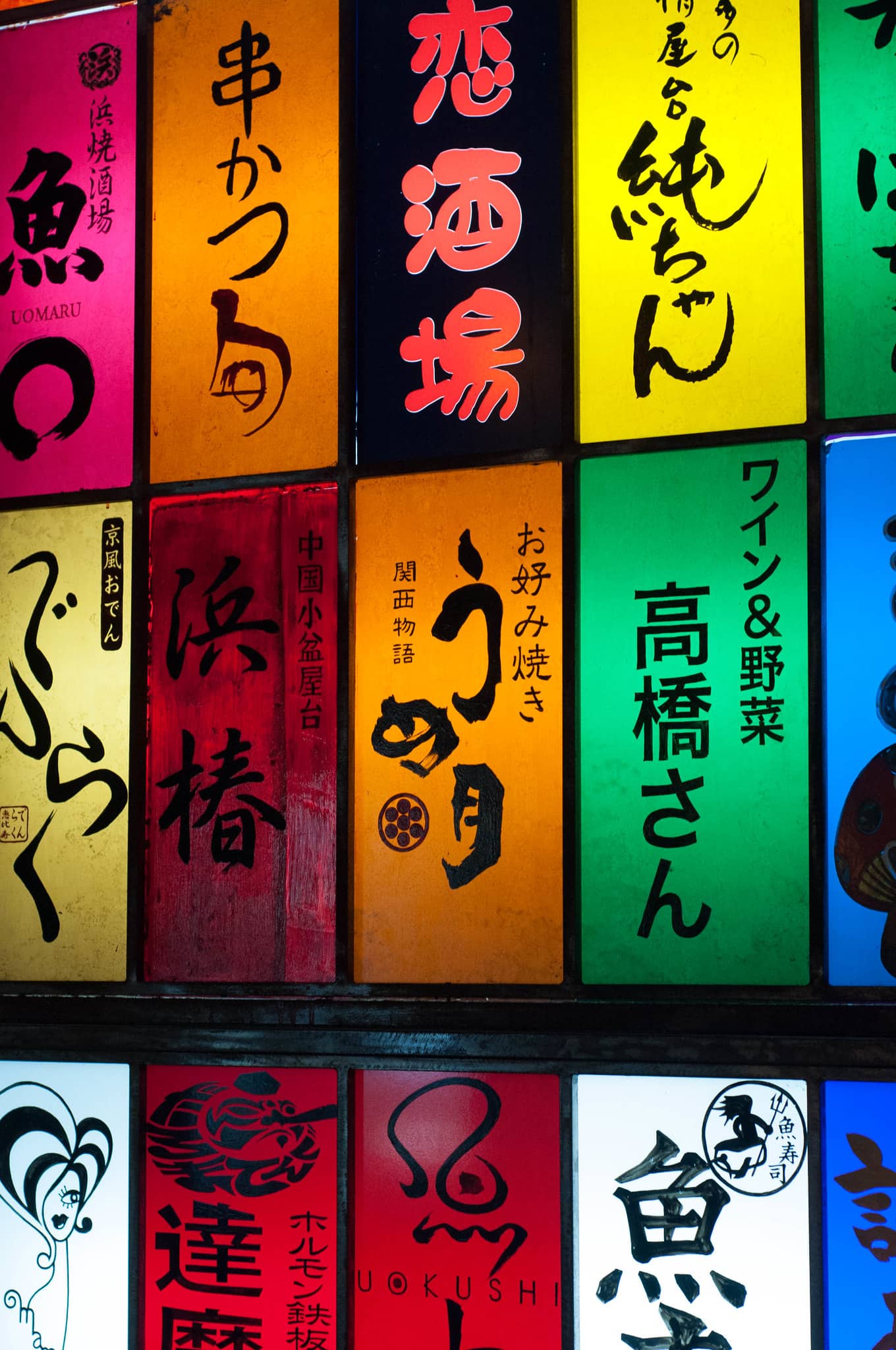 Colourful hand-painted stall signboards above the entrance to Ebisu Yokocho food alley