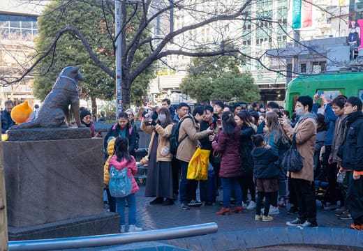 Visitors queueing for photos with the bronze Hachiko statue outside Shibuya Station