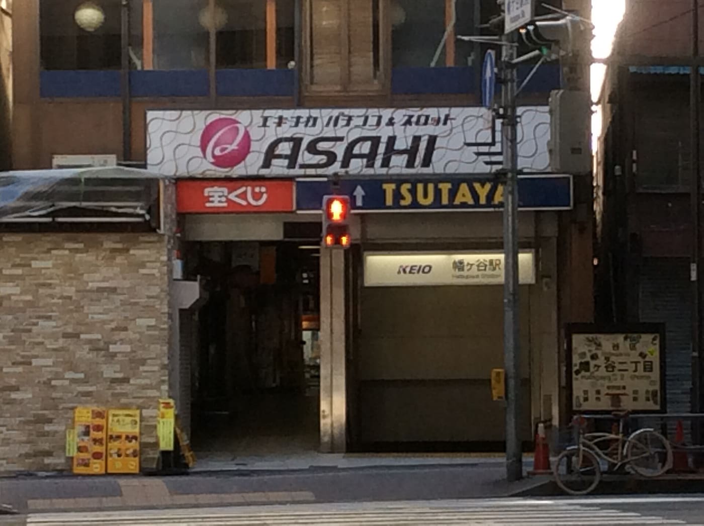 Hatagaya Station exit tucked between shopfronts on Koshu Kaido in Shibuya ward