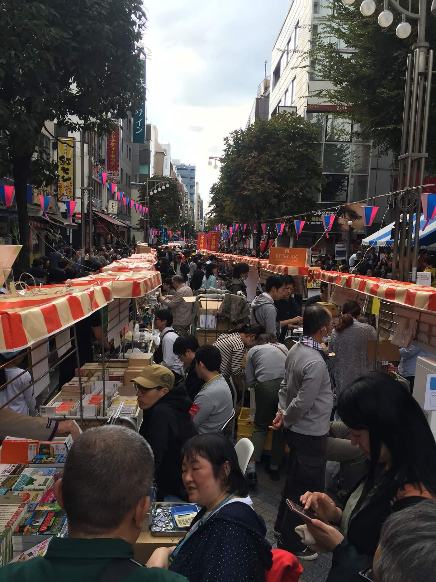 Crowds browsing rows of stalls at the Jimbocho Book Festival on the book-town street