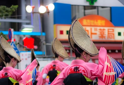 Awa Odori dancers in straw hats and pink yukata parading through Koenji streets in August