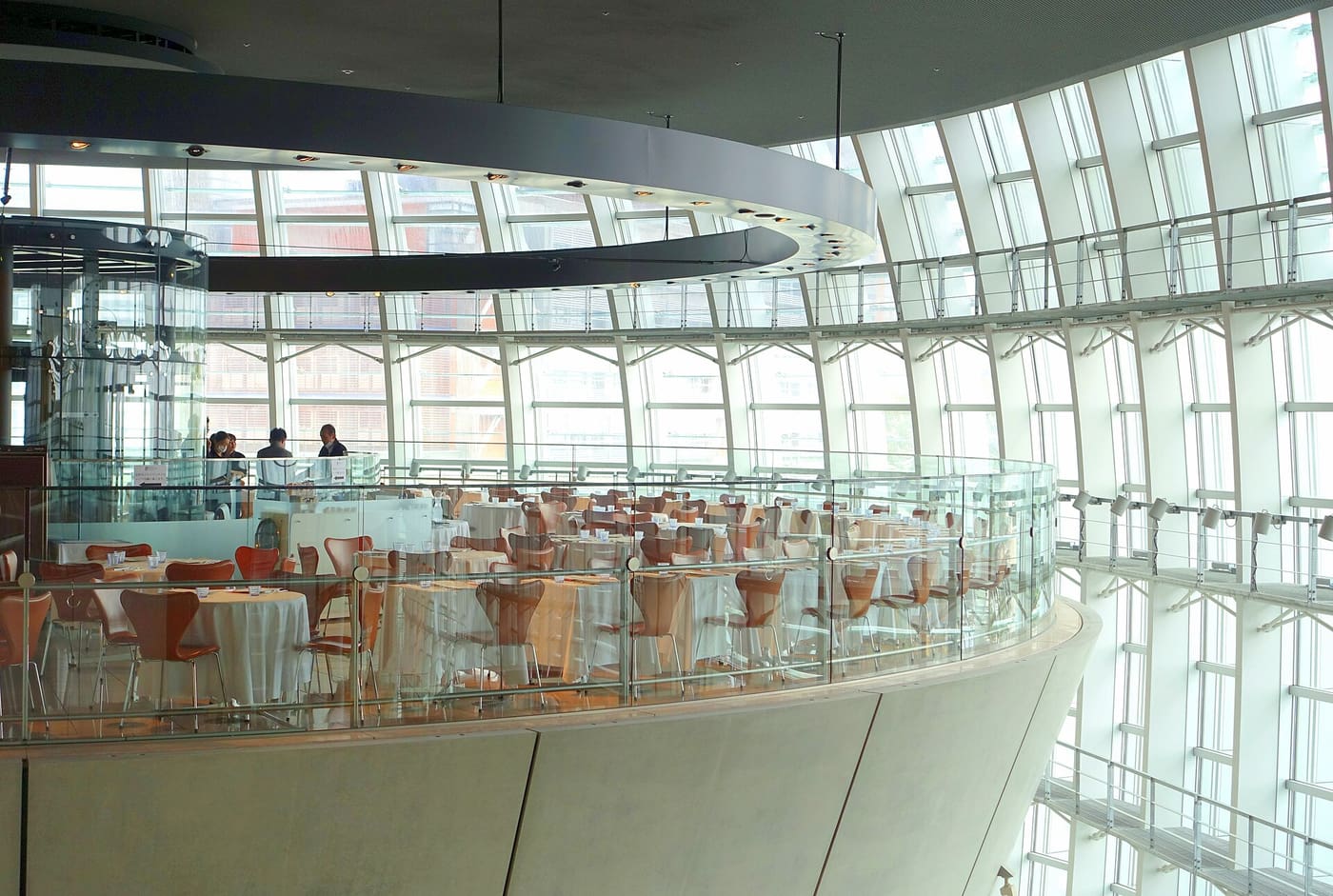 Restaurant tables on top of the inverted concrete cone inside The National Art Center atrium
