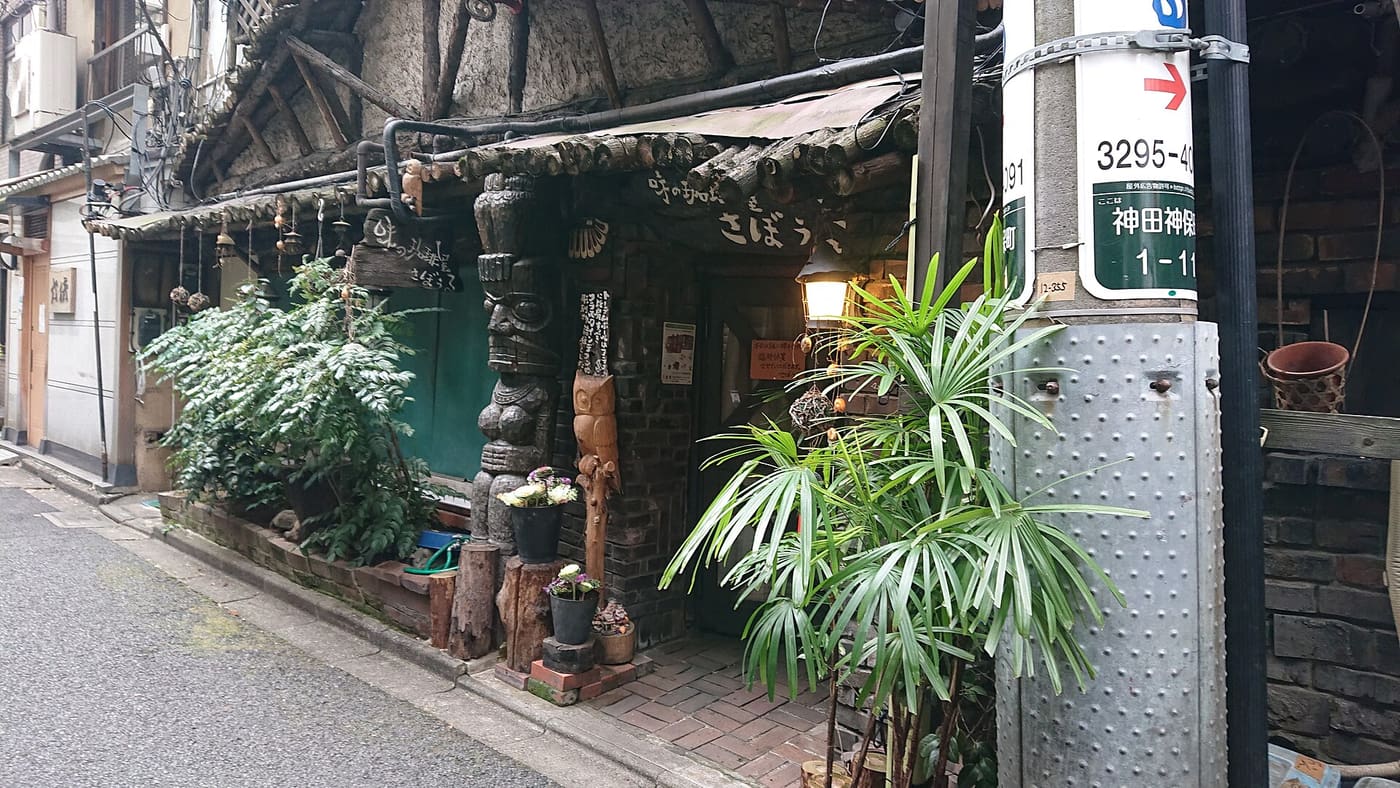 Plant-covered wooden entrance of Sabouru, the old kissaten in a Jimbocho side lane