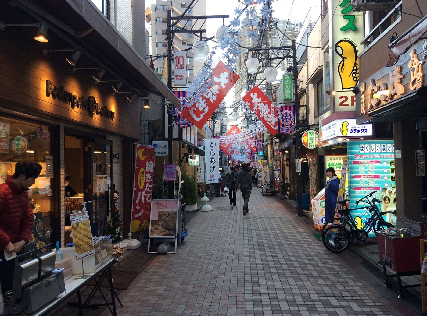 Bakery, small restaurants and shop banners along a Sasazuka shotengai in the afternoon