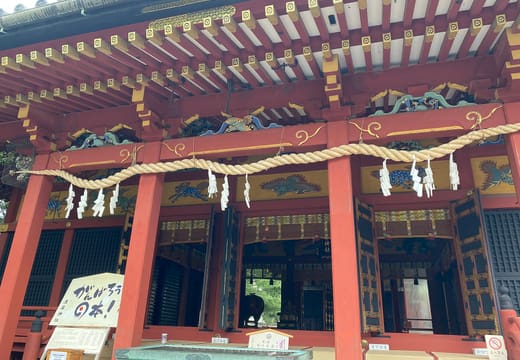 Red lacquered front of the Asakusa Shrine hall with its shimenawa rope and carvings
