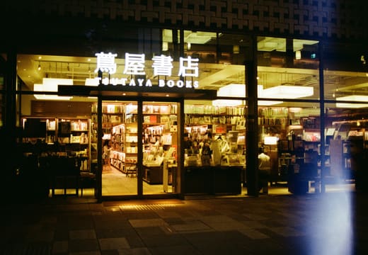 Warm lights of Tsutaya Books glowing through the glass at Daikanyama T-Site at night