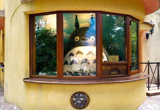 Totoro peering from the window of the fake ticket booth at the Ghibli Museum entrance
