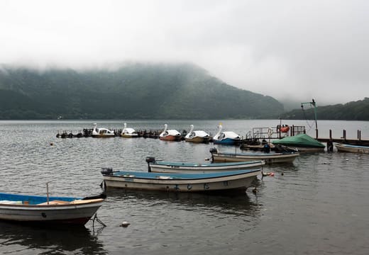 Rowboats moored on misty Lake Ashi below the Hakone hills