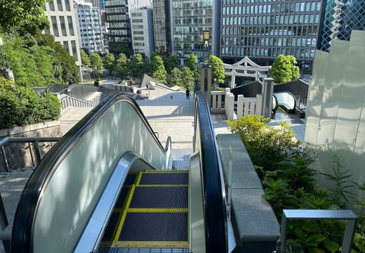 Outdoor escalator running up the wooded hill to Hie Shrine beside Akasaka office towers
