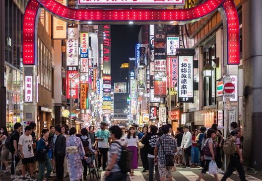 Red neon Kabukicho Ichiban-gai arch over crowds on a busy night in Shinjuku