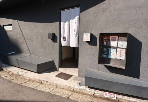 White noren curtain at the dark grey entrance of Kairyoyu sento in Higashi, Shibuya