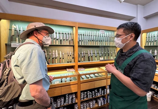 Customer choosing a kitchen knife with a shop assistant at a Kappabashi knife store