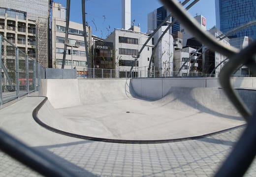 Concrete bowl of the rooftop skate park under the steel arches of Miyashita Park, Shibuya