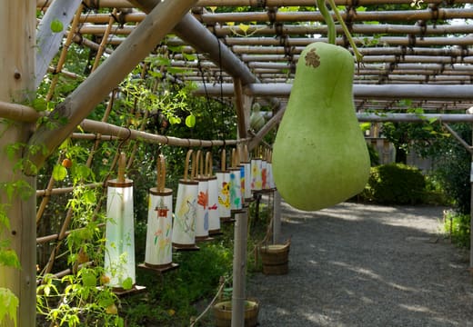 Gourd hanging from a bamboo trellis tunnel with poem slips at Mukojima-Hyakkaen Garden