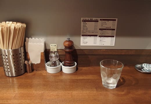 Counter seat with chopsticks, condiments and menu inside Nakiryu, Otsuka