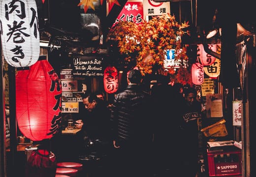 Red lanterns glowing along the yakitori alley of Omoide Yokocho at night