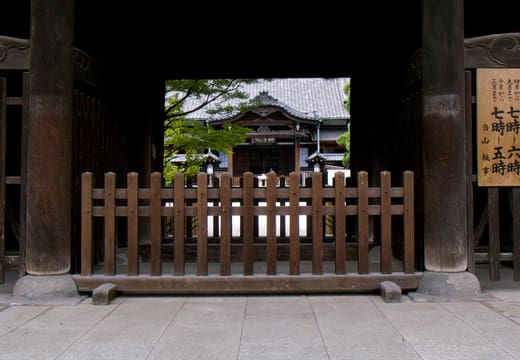 Chumon inner gate of Sengakuji with its carved name plaque framing the temple beyond