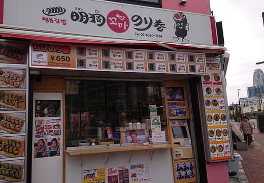 Street stall selling Korean gimbap rolls with a picture menu in Shin-Okubo
