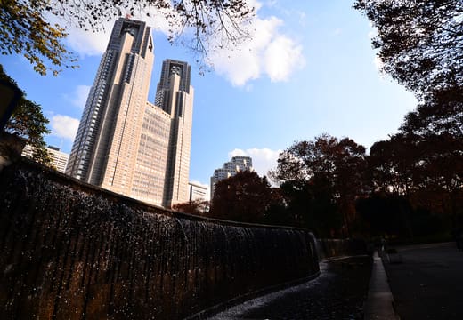 Behind the Niagara Falls waterfall wall with the Tokyo Metropolitan Government towers above, Shinjuku Chuo Park