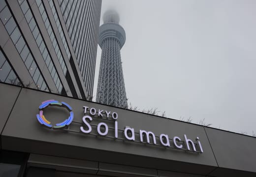 Tokyo Solamachi logo sign over the mall entrance with Tokyo Skytree rising into mist