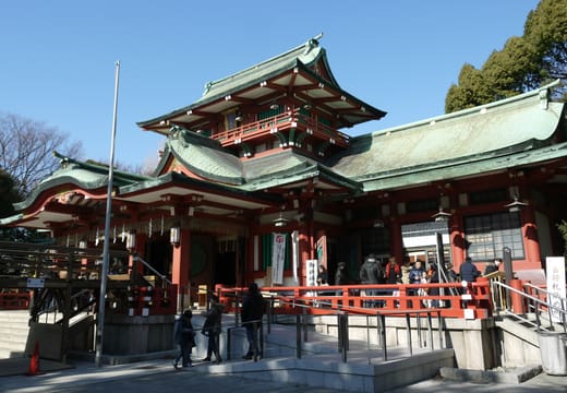 Gilded gables of the Tomioka Hachimangu worship hall against a deep blue sky
