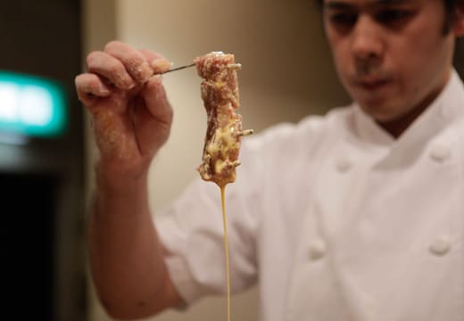 Cook dipping a pork cutlet in batter before frying at Tonki tonkatsu restaurant, Meguro