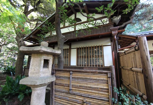 Stone lantern and bamboo fence beside the Koyo-an teahouse in Tonogayato Garden, Kokubunji