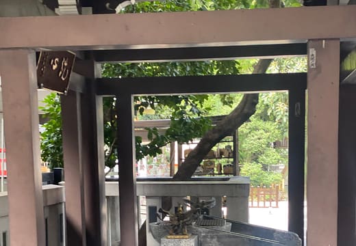 Stone chozuya purification basin under a wooden roof at Torigoe Shrine, Taito