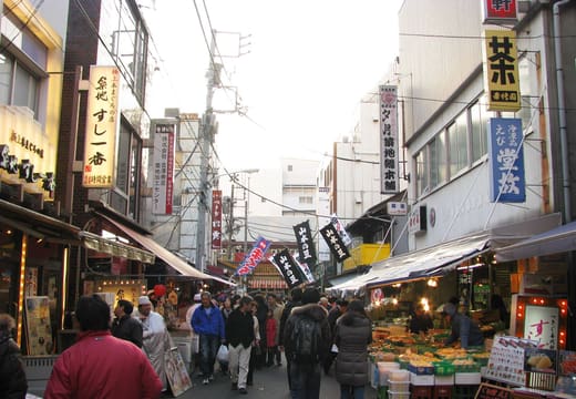 Shoppers in a busy lane of seafood and produce stalls at Tsukiji Outer Market