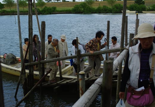 Passengers stepping off the Yagiri no Watashi ferry onto the wooden landing