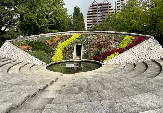 Circular Tokyo Air Raid victims memorial with flower beds in Yokoamicho Park