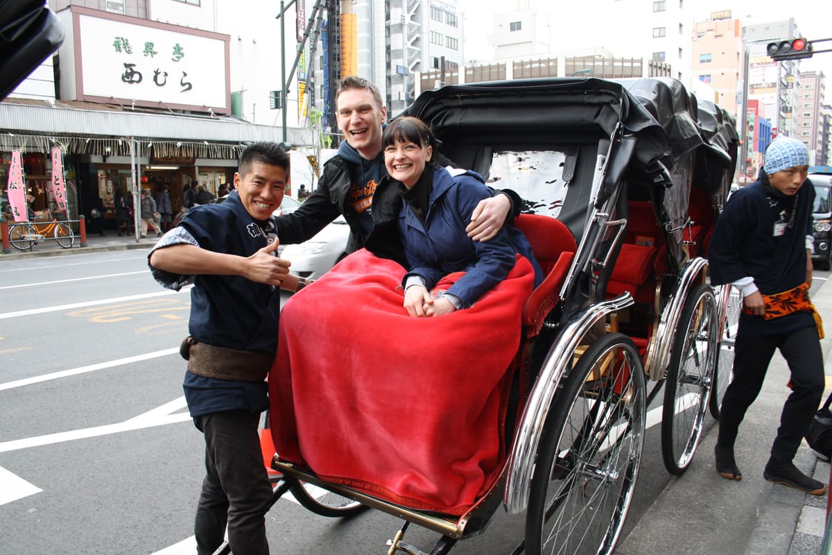 Un tireur de pousse-pousse et ses passagers dans une rue d’Asakusa
