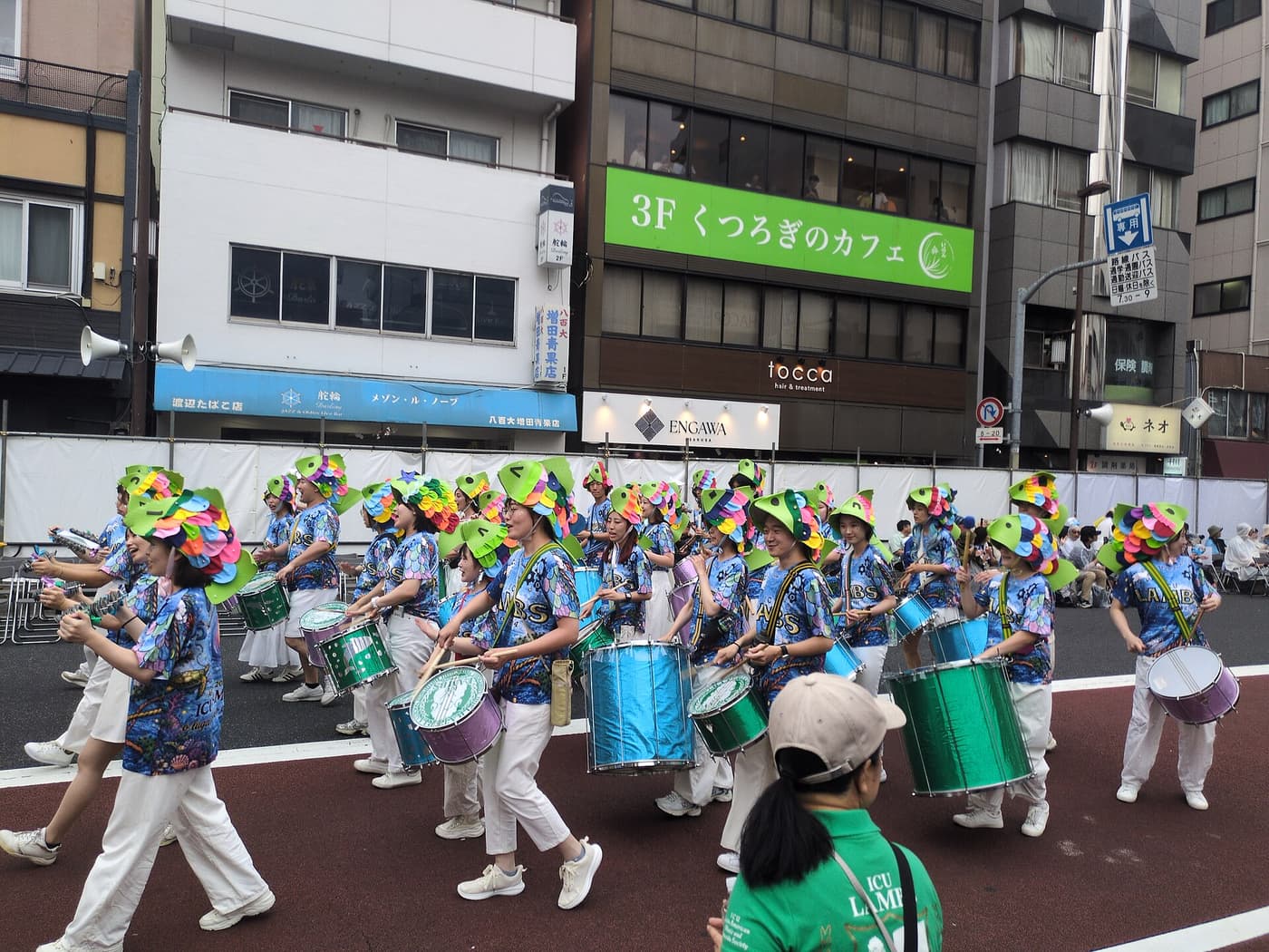 A samba percussion band marching down the closed road past crowds in Asakusa