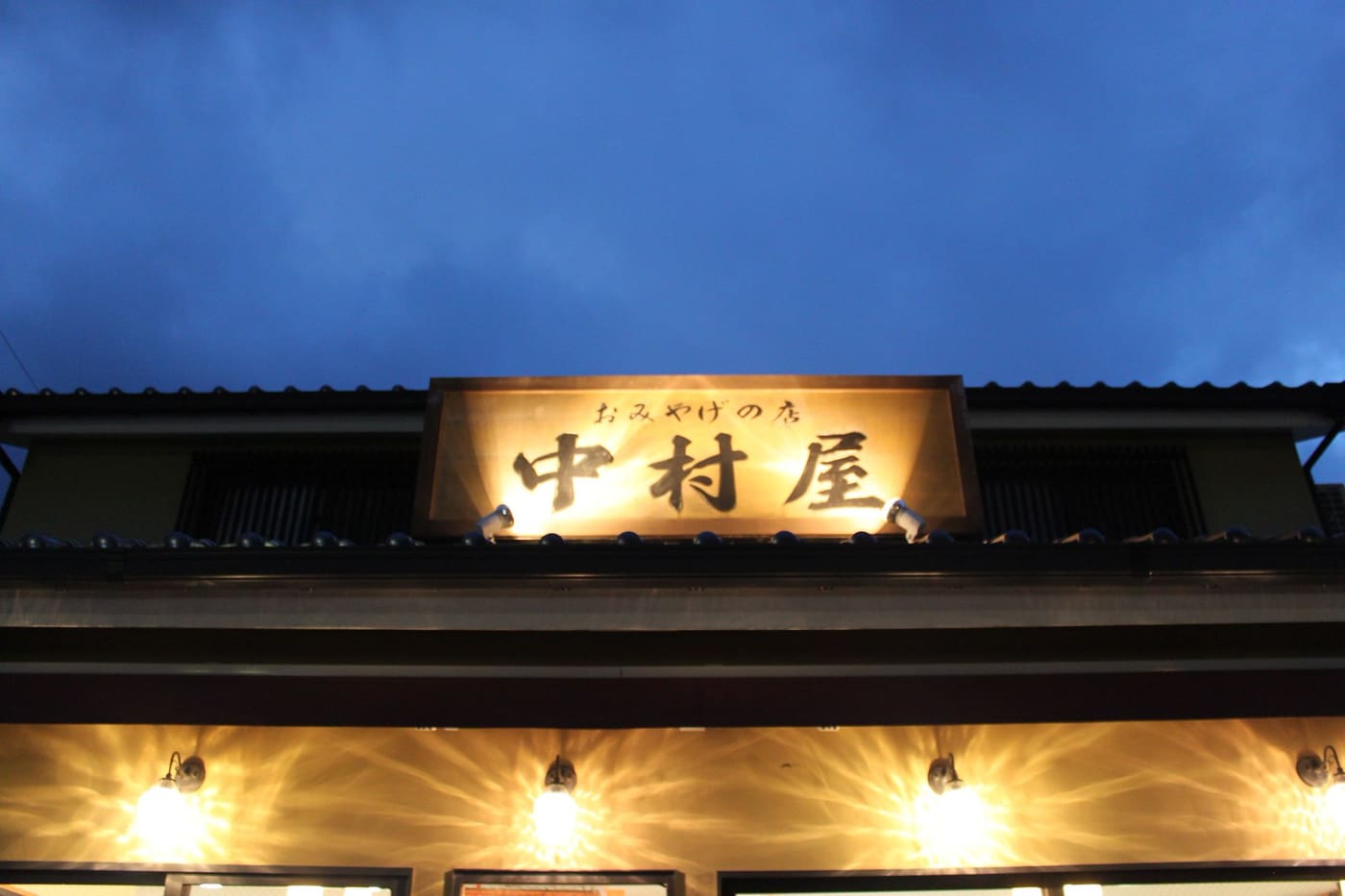 L’enseigne en bois éclairée d’un ryokan à Gora, Hakone, au crépuscule