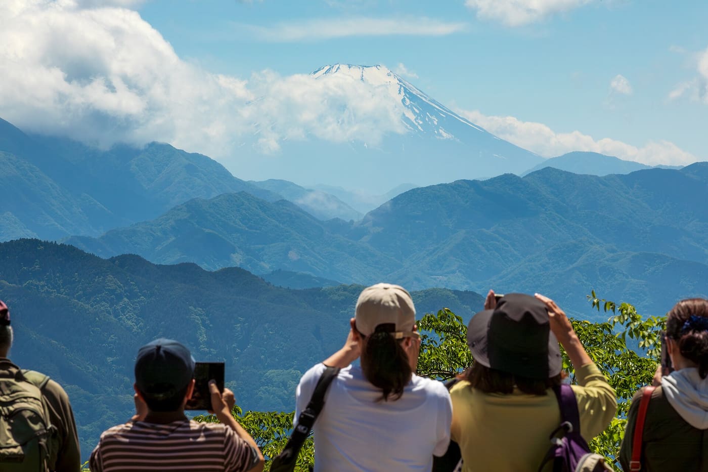 Hikers looking out at Mount Fuji from the summit viewpoint of Mount Takao