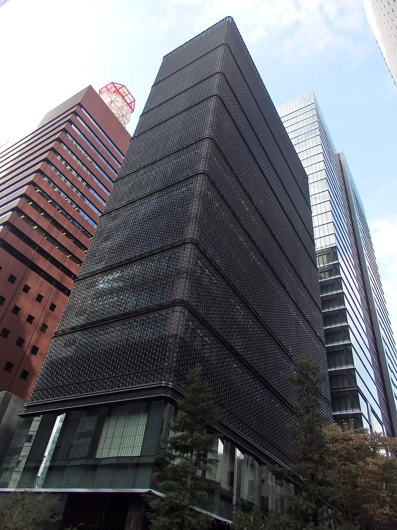 La façade en treillis sombre du Hoshinoya Tokyo parmi les tours de bureaux d’Otemachi