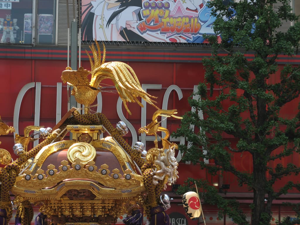 A mikoshi carried past shopfronts in Akihabara during the Kanda Matsuri