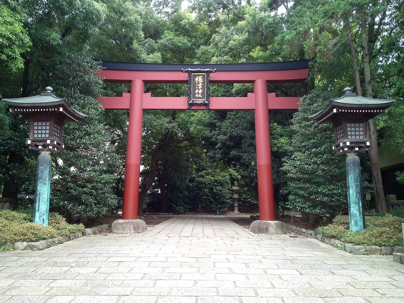 The vermilion torii and stone lanterns at the entrance to Nezu Shrine