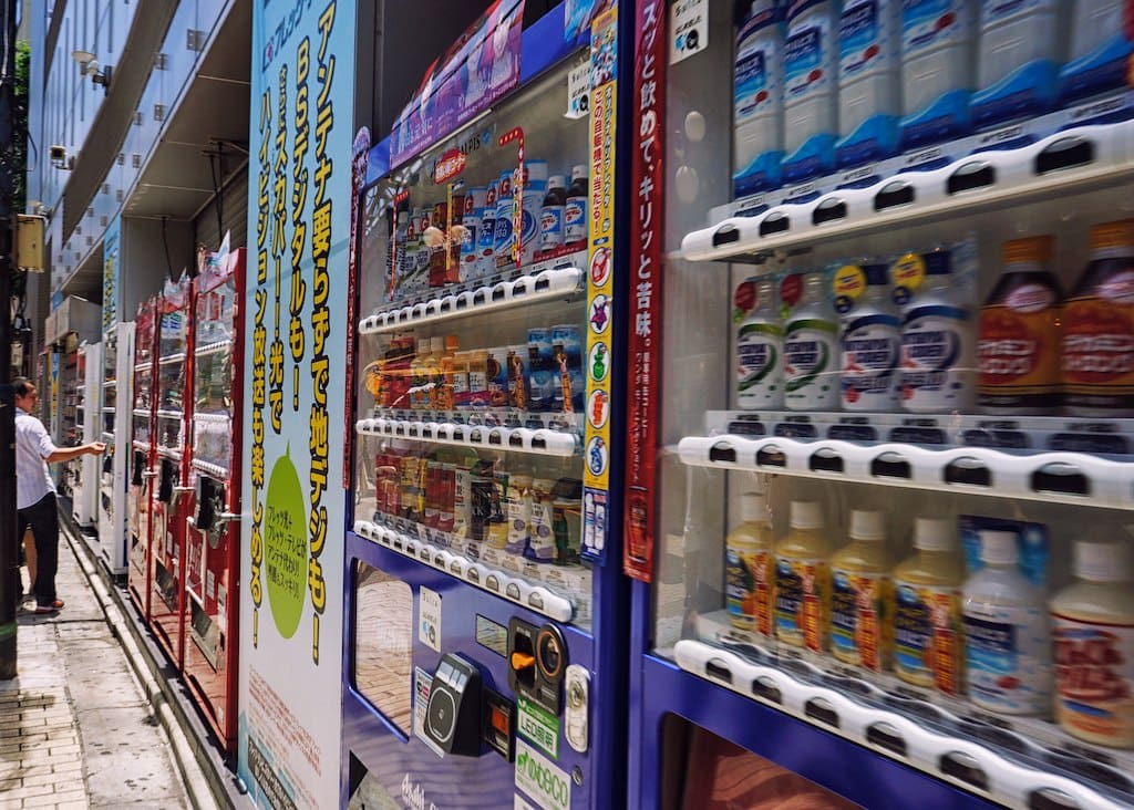 A row of drink vending machines lining a street in Tokyo