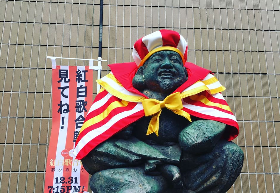 Bronze statue of Ebisu, god of good fortune, in a festive robe at Ebisu Station
