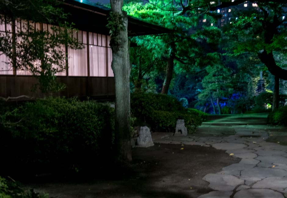 Lantern-lit teahouse and stone path in the Japanese garden of Happo-en at night, Shirokanedai