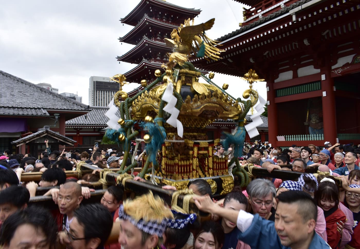 A golden mikoshi carried through the crowd in front of Senso-ji during Sanja Matsuri
