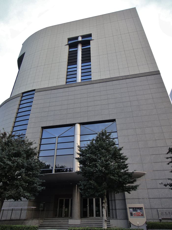 Curved stone facade and glass entrance of Kioi Hall in Kioicho, Chiyoda