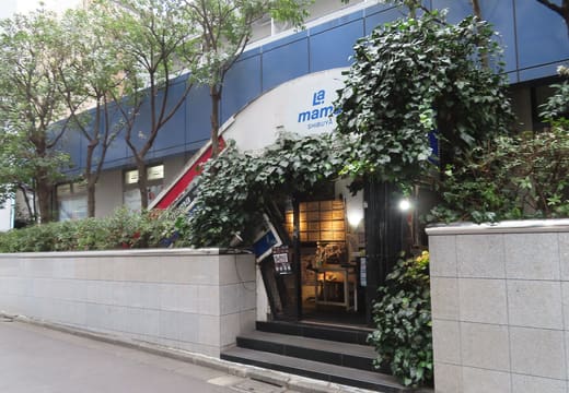 Ivy-framed street entrance and sign of Shibuya La.mama on Dogenzaka