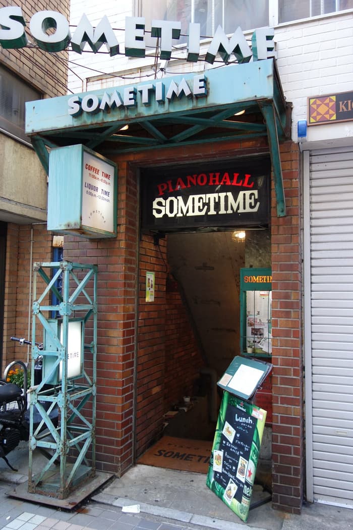 The entrance of Sometime in Kichijoji, a brick doorway under its green SOMETIME signs