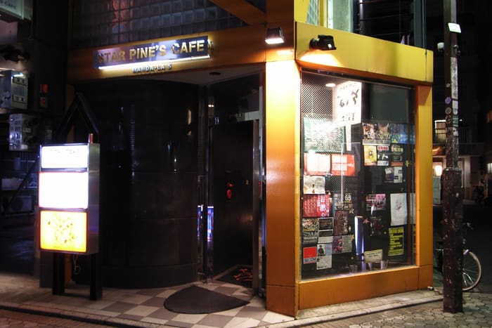 Orange-framed street entrance of Star Pine's Cafe in Kichijoji at night