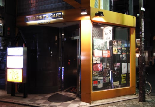 Orange-framed street entrance of Star Pine's Cafe in Kichijoji at night