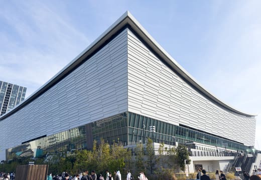 The curved silver facade of Tokyo Ariake Arena on the Ariake waterfront