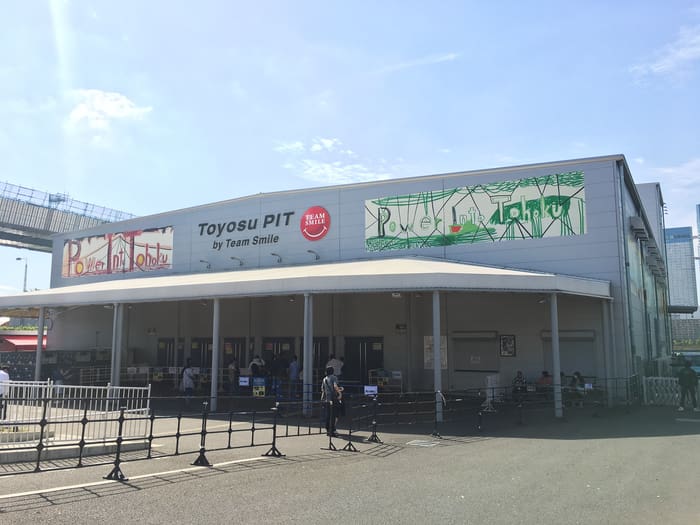 The long low hall and sign of Toyosu PIT by the Toyosu waterfront on a sunny day